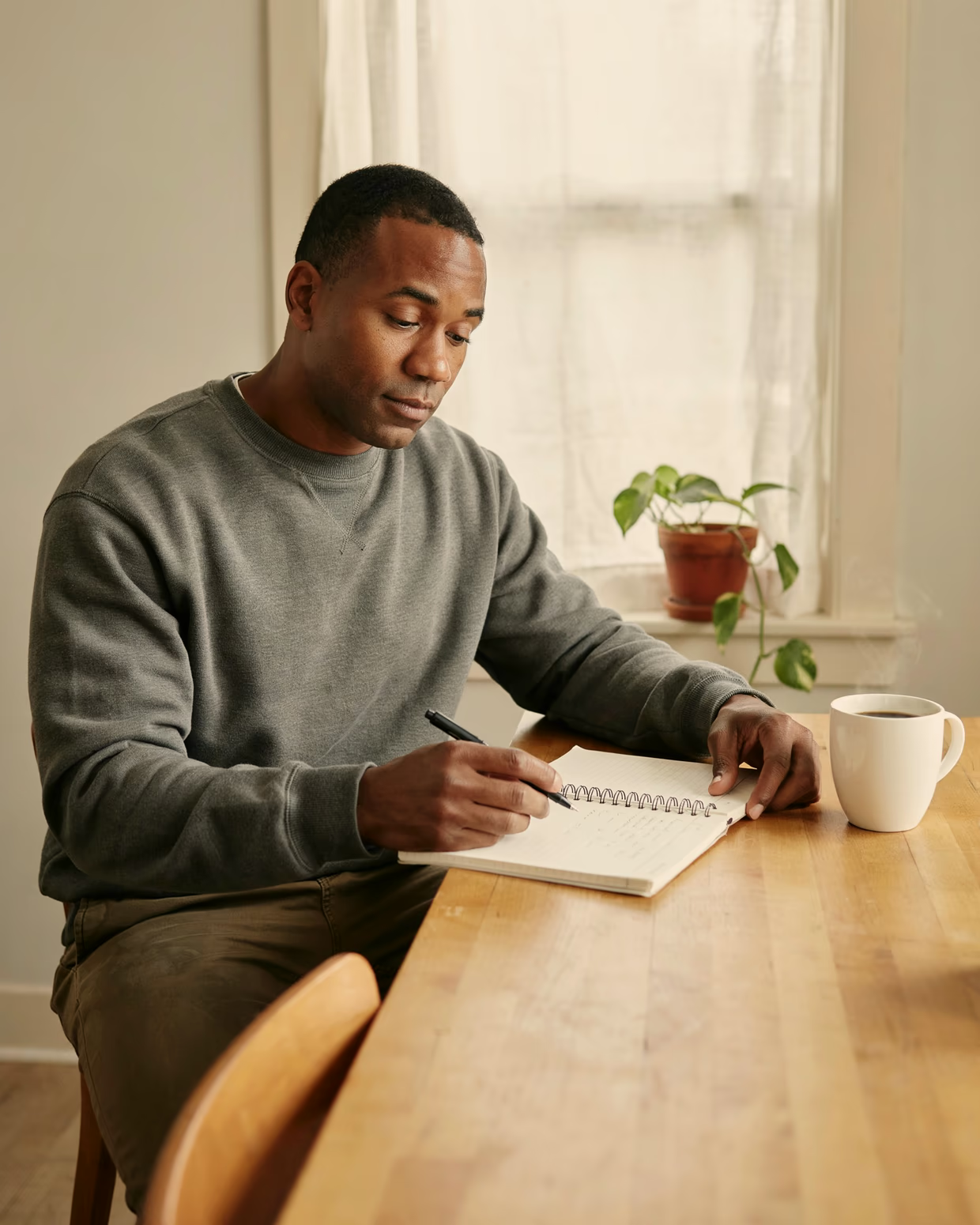 A man preparing a job application at his kitchen table